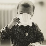 Kleiner Junge trinkt aus großer weißer Teetasse
