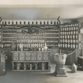 Fotografie der alten Ausstellung Fotografie der alten Ausstellung im Museum, schwarz/weiss, altes Apothekenmobiliar mit Gefässen und Werkzeugen