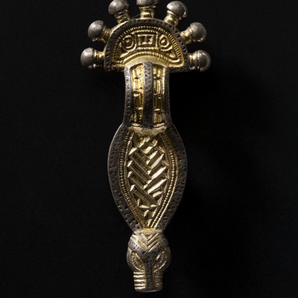 Bügelfibel mit Tierkopfabschluss, Silber, vergoldet, 6. Jh. Zur Frauentracht des 6. Jahrhunderts gehörten Bügelfibeln, die paarweise, häufig im Beckenbereich getragen wurden und wie Sicherheitsnadeln vielleicht einen Rock zusammenhielten.